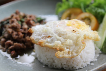 Stir-fried pork with basil leaves and fried egg on rice.
