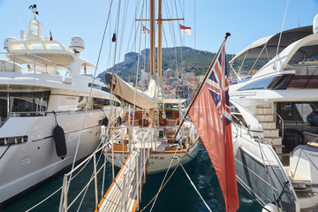 Obraz premium Monaco, Monte-Carlo, Monaco Ville, 8 August 2016: Port Hercules, the preparation of the yacht show MYS, sunny day, many yachts and boats, RIVA, Prince's Palace of Monaco, megayachts, Massif of houses