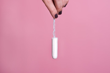 Woman's hand holding a clean cotton tampon - obrazy, fototapety, plakaty