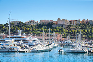Fototapeta na wymiar Monaco, Monte-Carlo, Monaco Ville, 8 August 2016: Port Hercules, the preparation of the yacht show MYS, sunny day, many yachts and boats, RIVA, Prince's Palace of Monaco, megayachts, Massif of houses