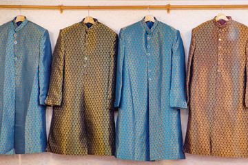 Traditional Indian men's clothing for sale at the street market in Chinatown district, Bangkok, Thailand. Achkan or Sherwani is a long jacket made of silk with buttons