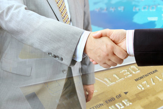 Closeup of handshake on credit cards background 