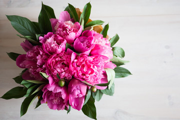pink peonies on wooden background