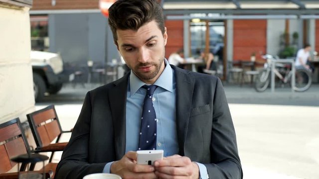 Worried businessman looking on smartphone and having problem, steadycam shot
