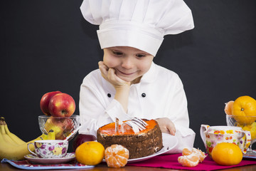 funny boy chef prepares a fruit cake
