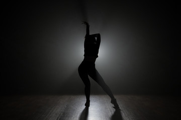 Naklejka na ściany i meble Dancer posing in the dark and smoke