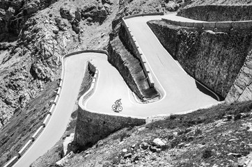 Fototapeta premium Famous Passo Dello Stelvio Road in Swiss - Italy border. Favourite place for all bike riders. Alone biker on the top.