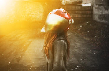 Photo of sexual biker girl in a red helmet and black jacket.