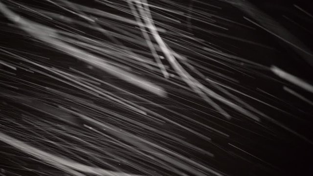 Night shot of snow falling on black background, low shutter speed shot