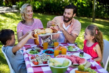 Cheerful family enjoying meal in yard 