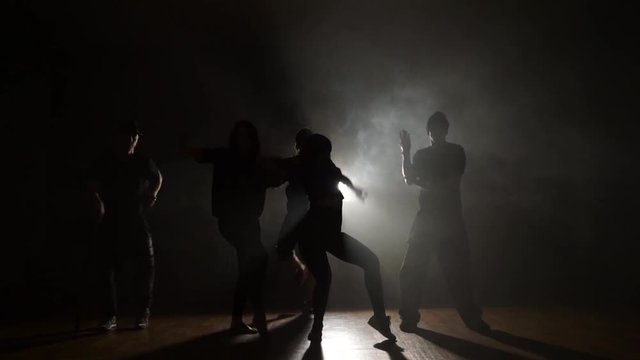 Five dancers dancing trendy dancing in smoke.