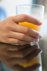 Woman hand holding glass of juice for drink.