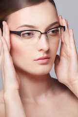 Close-up portrait of beautiful young woman in stylish glasses