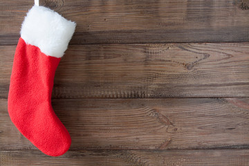 Obraz na płótnie Canvas Red Christmas sock on the brown wooden background
