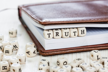Word TRUTH on old wooden table.