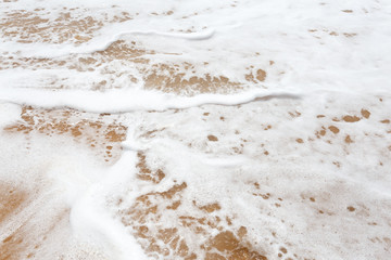 Fototapeta na wymiar Beautiful tropical waves foam on the beach