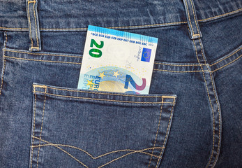 Banknote 20 euro sticking out of the back jeans pocket. Money fo