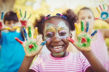 Portrait of a girl with make-up showing her painted hands