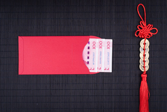 chinese lucky coins and red envelope on black bamboo mat
