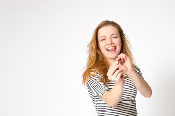 Portrait of a beautiful charming girl who plays and fooling around, holding a hair elastic