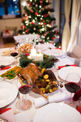 Christmas meal laid on table in decorated dining room.