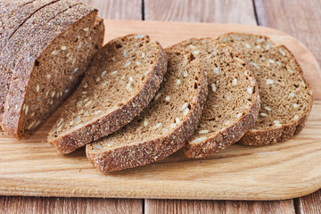 Slice of rye bread with seeds on a wooden background сlose up.