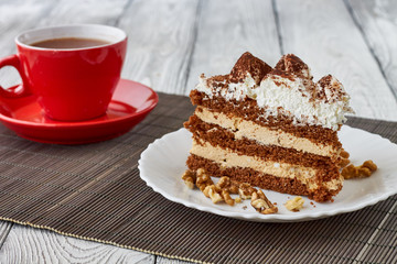 Tiramisu cake with walnuts and coffee on a wooden background