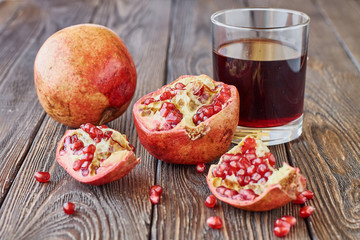 Obraz na płótnie Canvas Ripe pomegranates with juice on a wooden table