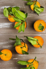 Tangerines with green leaflets on a dark wooden background. Top