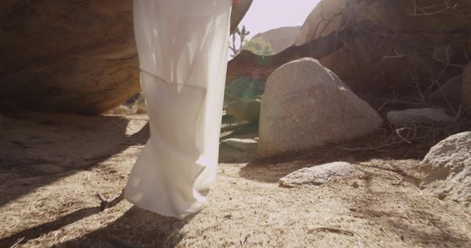 Girl walking in the desert through the rocks and caves. Mojave desert views. Slow motion