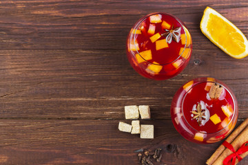 Mulled wine with citrus in glass on a dark wooden background. To