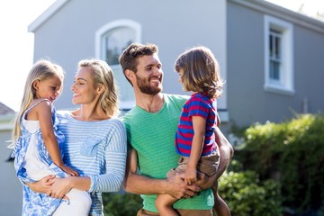 Parents carrying children in yard