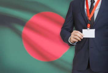 Businessman holding name card badge on a lanyard with a national flag on background - Bangladesh