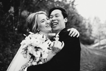 very happy bride and groom standing together outdoors