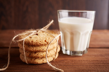 Cookies and milk. Chocolate chip cookies and a glass of milk. Vintage look. Tasty cookies and glass of milk on rustic wooden background. Food, junk-food, culinary, baking and eating concept
