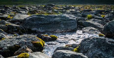 mountain stream between stones with moss