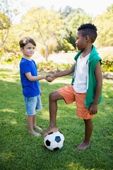 Obraz premium Portrait of cute football players handshaking 
