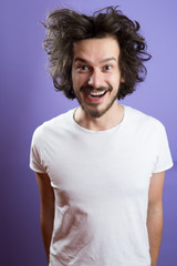 Beautiful caucasian man with funny hair over color background