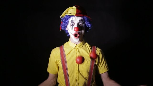 Scary mad Juggler clown using juggling pins. Terrible horror clown. HD.
