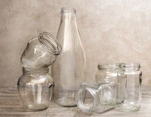 empty glass bottle and jars over wood