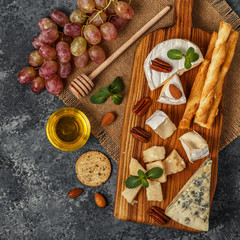 Fototapeta na wymiar Assortment of cheese with wine, honey, nuts and grape
