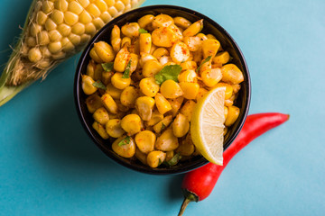 Steamed organic yellow sweet corn masala or corn chat prepared using butter, chat masala and lemon, favourite indian snack