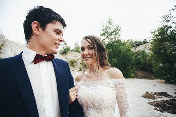 beautiful and happy groom and bride standing together outdoors