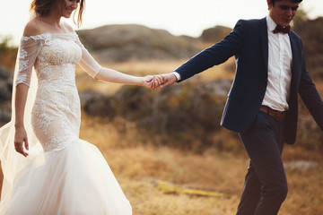 Fototapeta na wymiar beautiful and happy groom and bride walking together outdoors