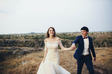 Fototapeta na wymiar beautiful and happy groom and bride walking together outdoors