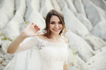 beautiful bride in a white dress stands outdoors
