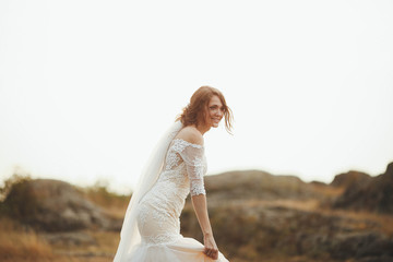 Fototapeta na wymiar beautiful bride in a white dress having fun outdoors