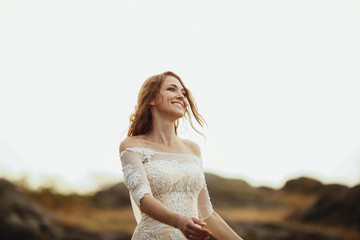 Fototapeta na wymiar beautiful bride in a white dress stands outdoors