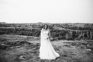 beautiful bride in a white dress stands outdoors