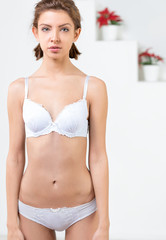 Obraz premium Beautiful slim woman wearing white lingerie. Studio shot of young seductive woman .